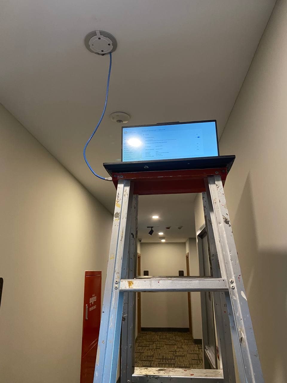 Engineer commissioning an access point from a ladder